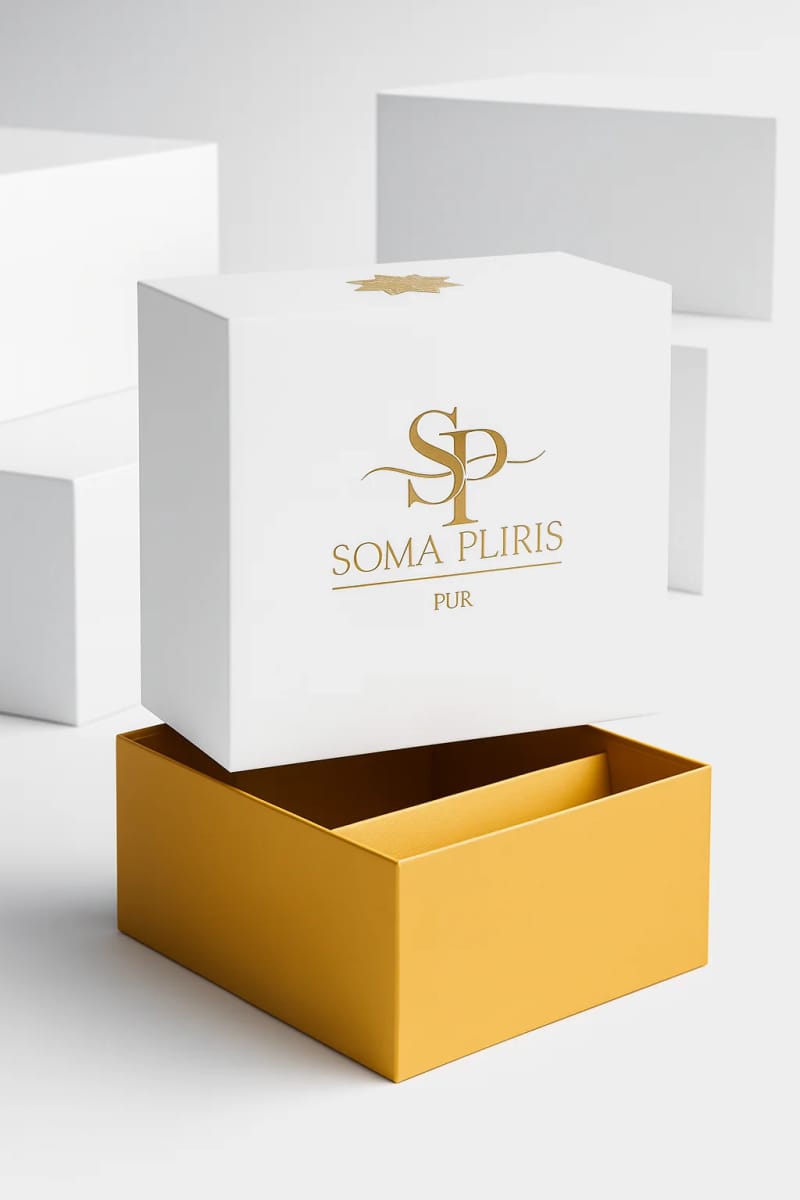 Coffret Soma Pliris Pur : boîte blanche aux lettres dorées, couvercle soulevé sur un intérieur doré.